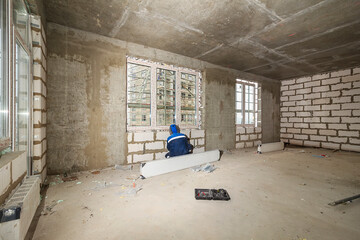 Drywall installation work in progress by construction workers at construction room. Construction...