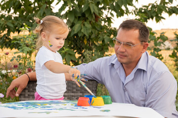 Happy father and adorable little daughter enjoying leisure time together. kid girl learning painting with father. 