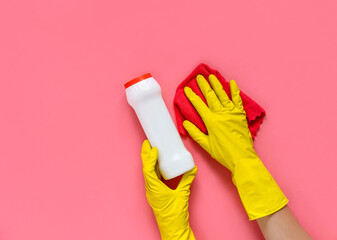 Woman's hand cleaning on a pink background.Cleaning or housekeeping concept background. Copy space. Flat lay, Top view.