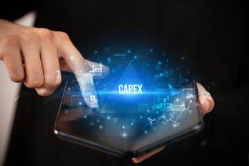 Businessman holding a foldable smartphone with CAPEX inscription, business concept