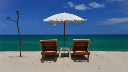Tropical beach, sunloungers and white parasol