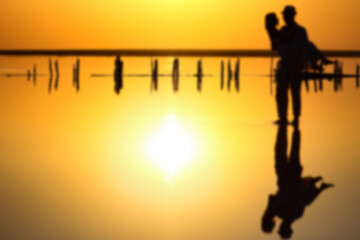 A happy couple at sea with water reflection silhouette background