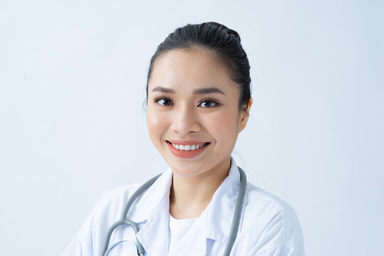Portrait of smiling young asian female doctor in a background for your text.