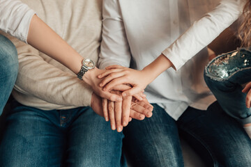 Obraz na płótnie Canvas Close up top view of stack hands lying on each other. Family showing unity and teamwork with putting arms together. Connection concept. Parents and children togetherness. 