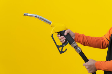 Woman hold fuel nozzle on yellow background