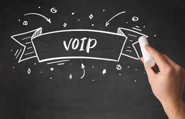 Hand drawing VOIP abbreviation with white chalk on blackboard