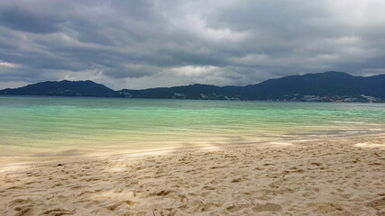 Storm over the mountains near Patong city in Phuket Island in Thailand. Beautiful view on the azure sea and golden sand.