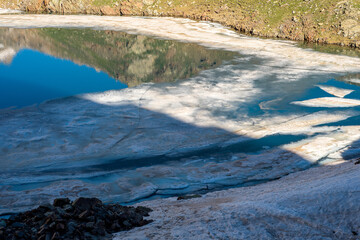 lac de montagne partiellement gelé en état de fonte au début de l'été 