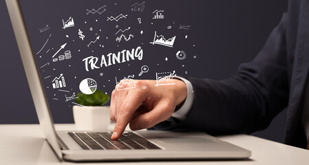 Businessman working on laptop with TRAINING inscription, modern business concept