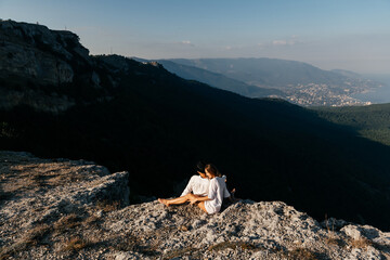 Couple of man and woman having rest on the top of mountain