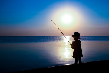 A Happy child fisherman fishing by the sea on nature silhouette travel