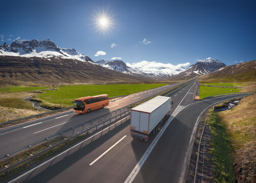 Travel bus and truck on the asphalt road in beautiful landscape at sunny day