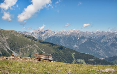 Fototapeta na wymiar Bank vor dem Alpenpanorama