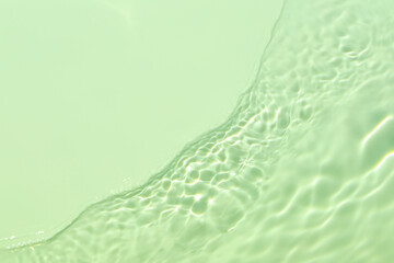 Closeup of mint green transparent clear calm water surface texture with splashes and bubbles....