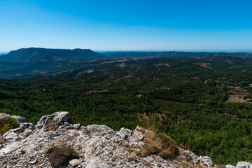 Landscape at the top of the mountain on a summer day with vegetation and trees and rocks with bright blue sky in Catalonia, Spain