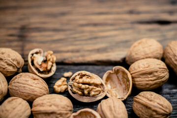 still life with Walnut kernels and whole walnuts on rustic old wooden table