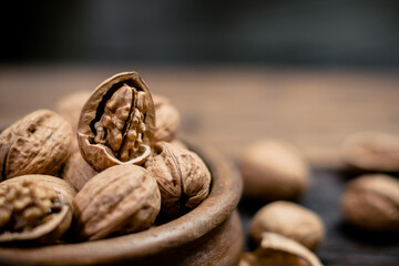 still life with Walnut kernels and whole walnuts on rustic old wooden table