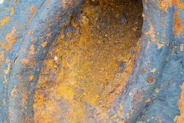 A close-up of an old industrial metal part with rust. Horizontal orientation, selective focus.