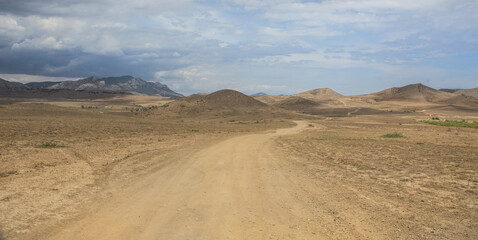 Fototapeta na wymiar Dirt road in mountainous terrain