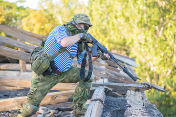 Fototapeta premium The airsoft player holds the defense, takes aim at the enemy