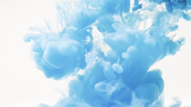 Abstract background of splashes of blue paint in water, an explosion of light blue color, splashes and spreading of bright paints
