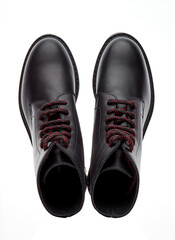 Black mountain boots made of durable leather, lace-up, with a massive sole, isolated on a white background with a shadow. Top view.