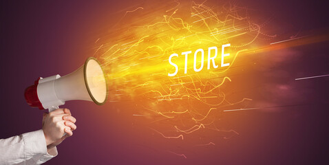 Young girld shouting in megaphone with STORE inscription, online shopping concept