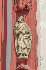 Fototapeta na wymiar Ancient wall sculpture of a monk at the main facade of Mary chapel in historical downtown of Wurzburg, Germany
