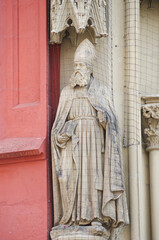 Fototapeta premium Ancient wall sculpture of a monk at the main facade of Mary chapel in historical downtown of Wurzburg, Germany