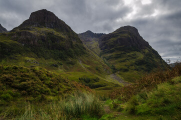 Mountain landscape in the Glen Coe with dark clouds hanging over the peaks, Highland, Scotland