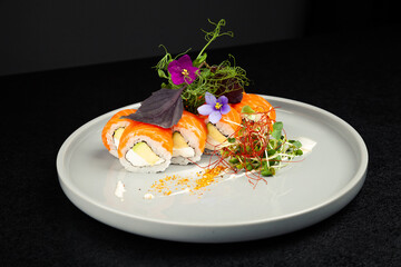 Sushi roll Philadelphia with avocado decorated with herbs on a plate, classic Japanese sushi. Traditional Japanese food with maki. Delicious pieces of sushi. For the restaurant menu. copyspace.