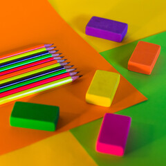neon pencils and some erasers on color background. Back to school tools