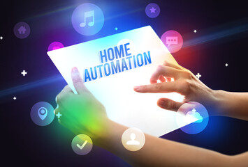 Holding futuristic tablet with HOME AUTOMATION inscription, new technology concept