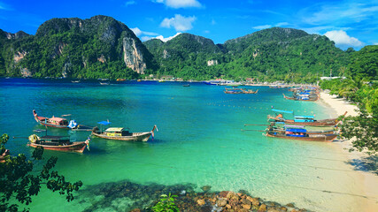 Obraz premium Beautiful view on the mountains and sea in the Phi Phi Don island near Phuket Island in Thailand. In the distance you can golden sand, azure water, thai boats and jungle in the mountains.