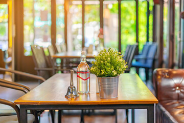 A small bell for calling the waiter and artificial flowers in an aluminum pot and drinking water...