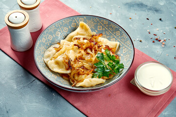 Ukrainian dumplings or Pierogi, Varenyky with filling and fried onions in a bowl.
