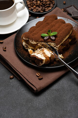 portion of Classic tiramisu dessert and cup of fresh espresso coffee on concrete background