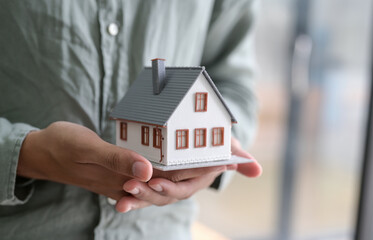Close-up shot of A person holding a model house in hand.For real estate concepts.