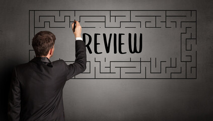 businessman drawing maze with REVIEW inscription, business education concept