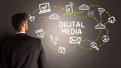businessman drawing social media icons with DIGITAL MEDIA inscription, new media concept