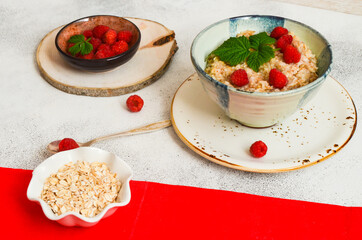 Delicious oatmeal porridge with ripe raspberries. Healthy and hearty Breakfast. The concept of diet and vegetarian food for a slim figure lifestyle