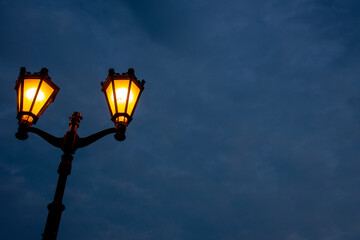 Fototapeta na wymiar A bright yellow lantern against a dark sky. Background for Halloween.