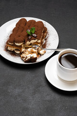 portion of Classic tiramisu dessert and cup of fresh espresso coffee on concrete background
