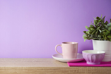 Kitchen utensils and dishware on wooden shelf. Kitchen interior purple background