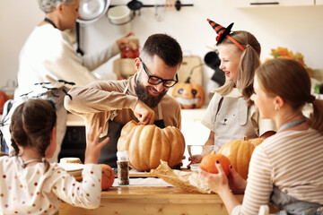 Multi generational family making jack o lantern.