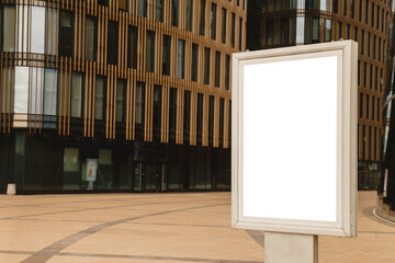Blank advertising billboard on front of business building. Banner on background of skyscraper is made in modern style. Architecture of building in business district of metropolis. Copyright space