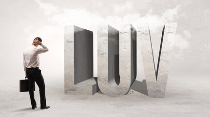 Fototapeta premium Rear view of a businessman standing in front of LUV abbreviation, attention making concept