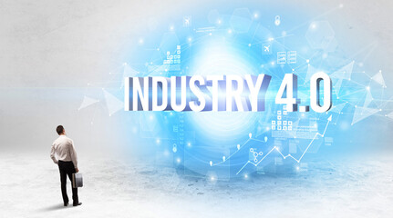 Rear view of a businessman standing in front of INDUSTRY 4.0 inscription, modern technology concept