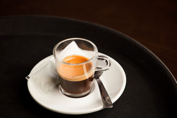 close-up detail cup of freshly brewed hot coffee, on top of the wooden table, inside the cafe and free space for decoration.