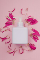 Obraz na płótnie Canvas Cosmetic jar of cream on pink background with delicate gerbera flower